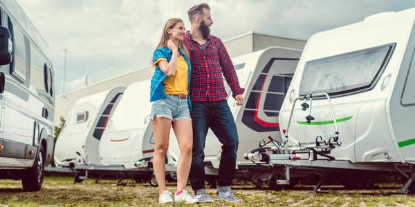 Man en vrouw kijken naar een caravan om te kopen