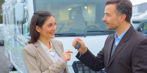 Un homme vend un camping-car à une femme